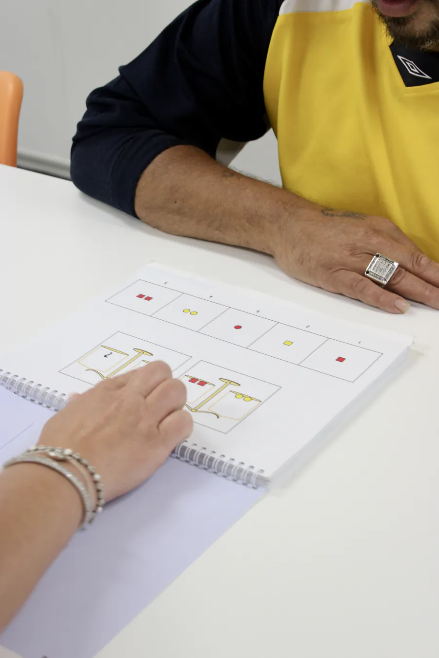 Cliënt en begeleider werken samen in een oefenboek