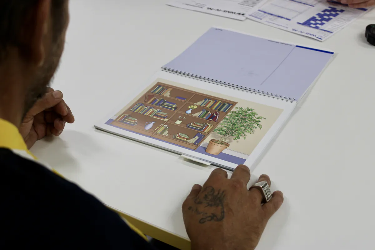 Cliënt bekijkt een werkboek tijdens de behandeling
